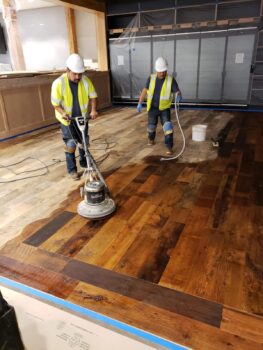 Deep cleaning hardwood floors entails buffing the Hardwax Oil directly onto the floors with a white polishing pad.